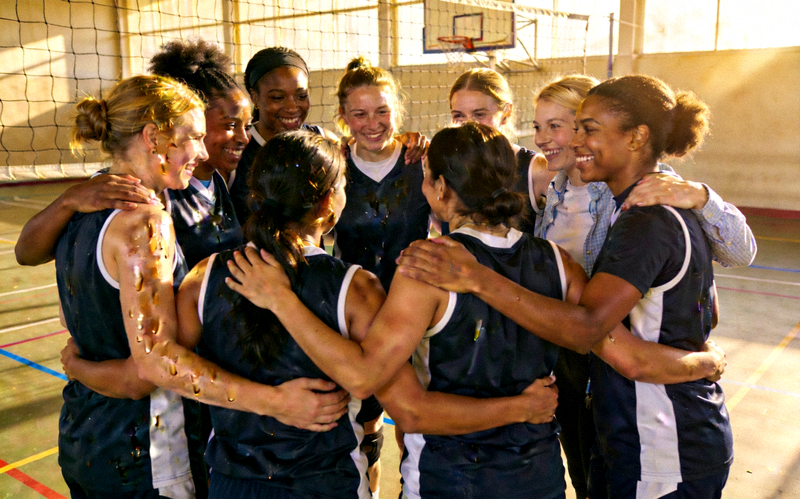 一支由不同职业女性组成的业余篮球队在赛后围成一圈互相鼓励